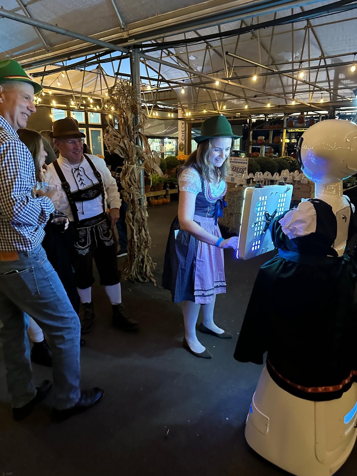 Guests posing with the robot photo booth in an Oktoberfest costume