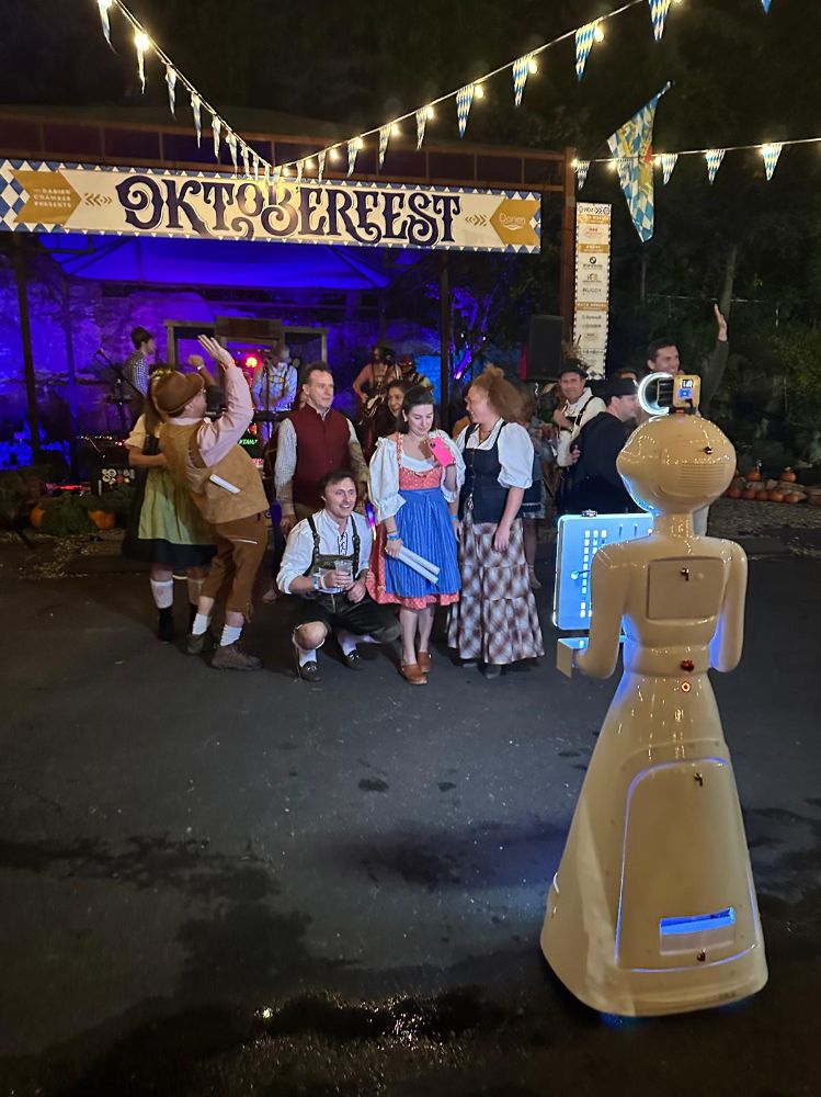 Guests posing with the robot photo booth at an Oktoberfest party